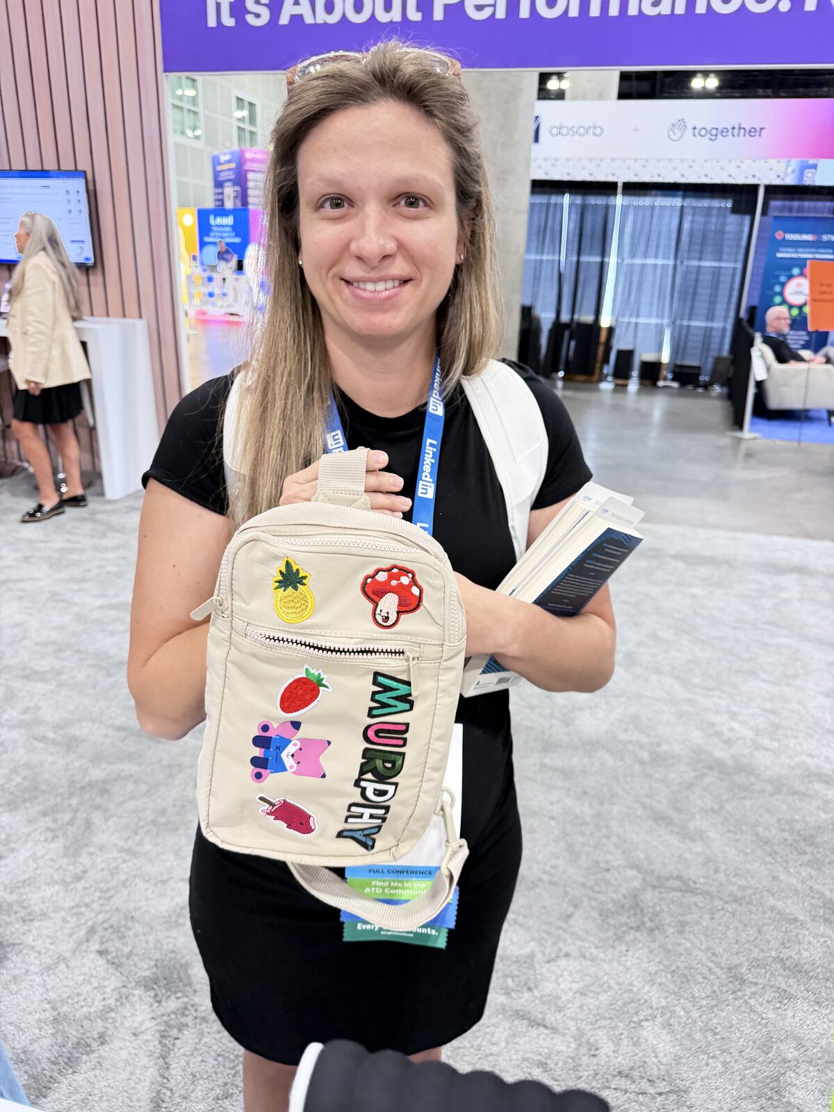 Person holding a custom decorated Murphy tote bag with embroidered patches at a corporate event